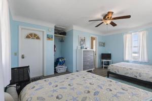 a bedroom with two beds and a ceiling fan at Quarter Deck Cottage on Flagler Beach in Flagler Beach