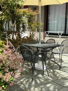 einen schwarzen Tisch und Stühle mit einem Sonnenschirm in der Unterkunft Hotel Delle Rose in San Bartolomeo al Mare