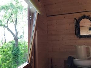 a bathroom with a window in a log cabin at Chambre des Anges & Roulotte proche Mont Saint-Michel, l'Angevinière in Saint-Laurent-de-Terregatte