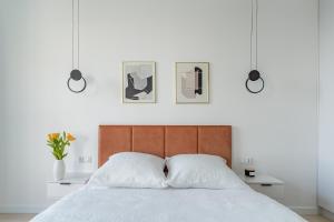 1 dormitorio con 1 cama con 2 almohadas blancas en Sea View Premium Apartment I PARKING - Widok na morze en Gdynia