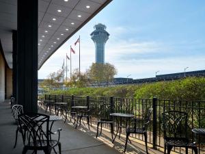 a row of tables and chairs with a control tower in the background at Hilton Chicago O'Hare Airport in Rosemont