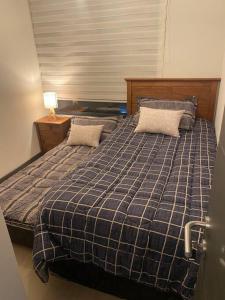 una camera con un letto con una coperta blu scozzese di Maravilloso Depto nuevo 2D 2B centro frente al lago a Puerto Varas