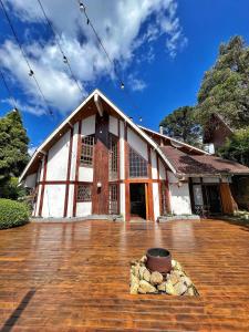 a large building with a wooden floor in front of it at Capivari Lodge in Campos do Jordão