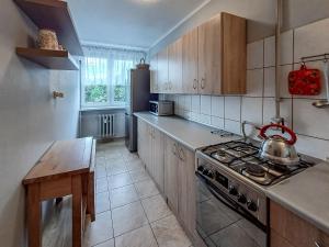 a kitchen with a stove and a table in it at Legnicka Budget Stay - Grysko Apartament's in Szczecin