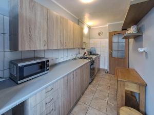 a kitchen with wooden cabinets and a microwave at Legnicka Budget Stay - Grysko Apartament's in Szczecin