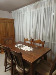 a dining room table with chairs and white curtains at Mieszkanie Mickiewicza ... 45 in Sandomierz