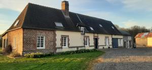 una antigua casa de ladrillo con techo negro en Le Thuit - F2 Plain pied tout équipé à la ferme, en Charleval