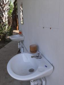 a bathroom with a white sink and a toilet at Playa Casa Nohelia in Santo Domingo