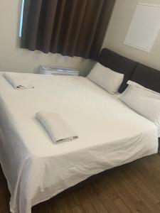 Una cama blanca con una toalla encima. en Savenella Apartments en Bolonia
