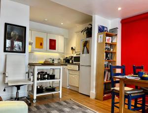 a kitchen with a table and a refrigerator and a table at Comfy child/dog friendly garden flat heart Camden in London