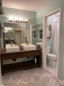 La salle de bains est pourvue de 2 lavabos et de toilettes. dans l'établissement Downtown Halifax suites, à Halifax