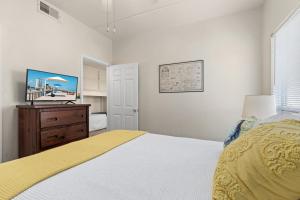 um quarto com uma cama, uma cómoda e uma televisão em Beachview Get-AWAY @ Fantasy Circle em South Padre Island