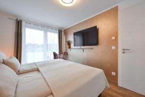 a bedroom with a large bed and a flat screen tv at Mensel City 2 in Füssen