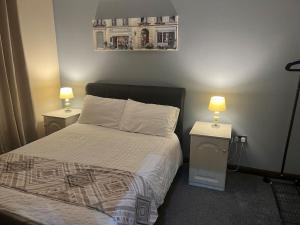 a bedroom with a bed and two tables with lamps at Promenade Sea View Apartment in Ballycastle