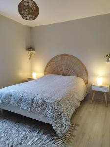 Maisons的住宿－Comme à la "MAISONS"，一间卧室配有一张大床和两盏灯。