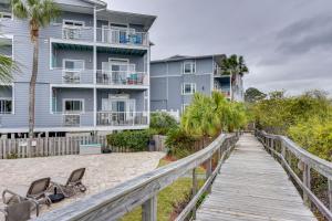 a boardwalk leading to the beach with a building at Breezy Tybee Island Condo - 100 Yards from Beach! in Tybee Island