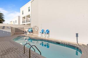 una piscina con sillas azules y un edificio en Beachview Get-AWAY @ Fantasy Circle, en South Padre Island