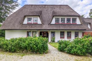 a white house with a thatched roof at Seestern in Vollerwiek