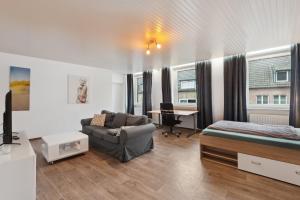 un soggiorno con letto, divano e scrivania di City-Wohnung direkt am Markt a Goch