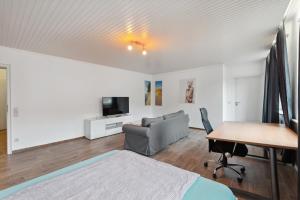 a bedroom with a bed and a table and a tv at City-Wohnung direkt am Markt in Goch