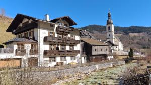 a building next to a river with a church at Ferienwohnung im Gästehaus Sieger-Brandner in Ramsau