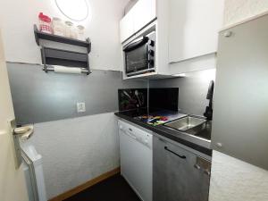 a small kitchen with white cabinets and a sink at PIERRER G - Appartement PIERRER 10 pour 4 Personnes 41 in Valmorel