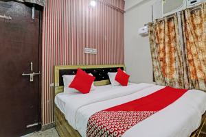 a bedroom with a large bed with red pillows at OYO Flagship MH Palace in Lucknow