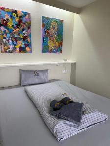ヴァンガーオーゲにあるAlbatrosの壁に絵画が2点飾られた部屋のベッド1台