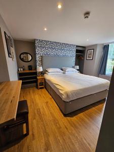 um quarto com uma cama grande e piso em madeira em Cockhaven Arms em Bishopsteignton