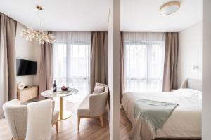 um quarto com uma cama, uma mesa e cadeiras em Golden Apartment Paupys em Vilnius