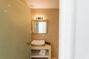 łazienka z umywalką i lustrem w obiekcie Enalion White Suites Oia w mieście Oia +27 zdjęć