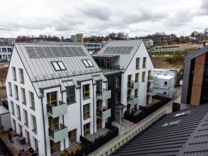 una imagen de dos edificios con paneles solares en sus tejados en Golden Apartment Paupys, en Vilna