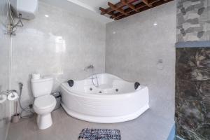 a bathroom with a white tub and a toilet at Villa Orenda 3-bedroom&3-bathroom in Sanur