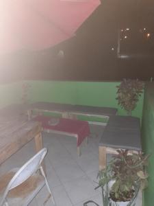Habitación con mesa, bancos y macetas. en chez albino guest house en São Filipe
