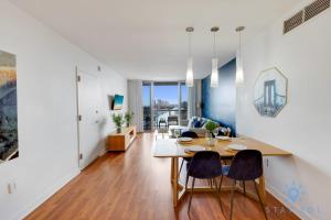 a dining room and living room with a table and chairs at Infinite View Balcony - Amazing Pool - Gym in Hallandale Beach