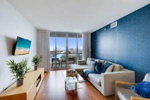 a living room with a couch and a blue wall at Infinite View Balcony - Amazing Pool - Gym in Hallandale Beach