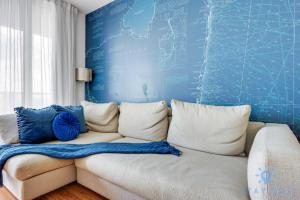 a couch in a room with a blue wall at Infinite View Balcony - Amazing Pool - Gym in Hallandale Beach