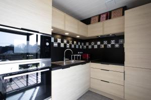 una cucina con mobili in legno e un lavello di Le Chalet Cetri - Welkeys a Saubrigues