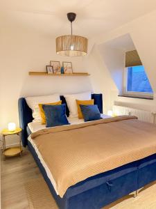 een slaapkamer met een bed met blauwe en gele kussens bij soulscape Apartments Zwickau kompakter LOFT-Wohnraum mit Lift direkt in die Wohnung, modern, zentrumsnah, gratis WIFI in Zwickau