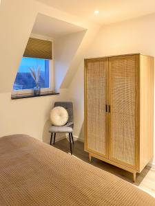 1 dormitorio con 1 cama, 1 silla y 1 ventana en soulscape Apartments Zwickau kompakter LOFT-Wohnraum mit Lift direkt in die Wohnung, modern, zentrumsnah, gratis WIFI en Zwickau