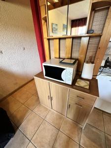 a microwave sitting on top of a wooden cabinet at Résidence Les Glovettes - Studio pour 4 Personnes 954 in Villard-de-Lans