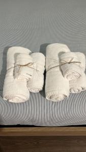 three rolled towels sitting on a bed at Voyager in Cagliari