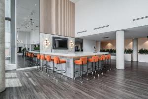 um átrio com um bar com bancos de bar laranja em Modern 1BR King Bed Condo - Private Balcony em Kitchener