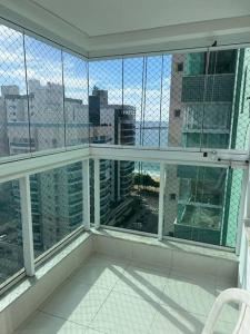 een kamer met een balkon met uitzicht op de stad bij Apartamento Edificio Sunset 1404 in Vila Velha +10 foto's