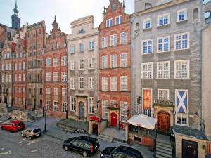 un groupe de bâtiments avec des voitures garées dans un parking dans l'établissement Apartament Kameralny 65 na Starówce, à Gdańsk