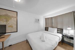 - une chambre blanche avec un grand lit blanc et un bureau dans l'établissement Renovated Gem: Prime Spotless Ideal, à Miami