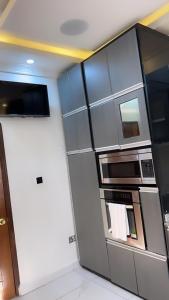 a kitchen with a refrigerator and a microwave at Bash luxury apartments in Freetown