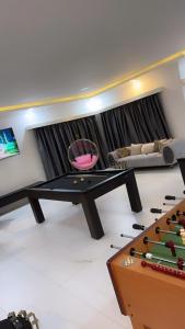 a living room with a ping pong table and a couch at Bash luxury apartments in Freetown