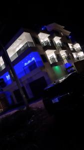 a building with blue and green lights on it at Bash luxury apartments in Freetown