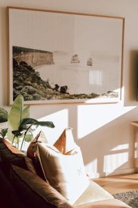 uma sala de estar com um sofá e uma fotografia na parede em Ocean Oasis Port Campbell em Port Campbell